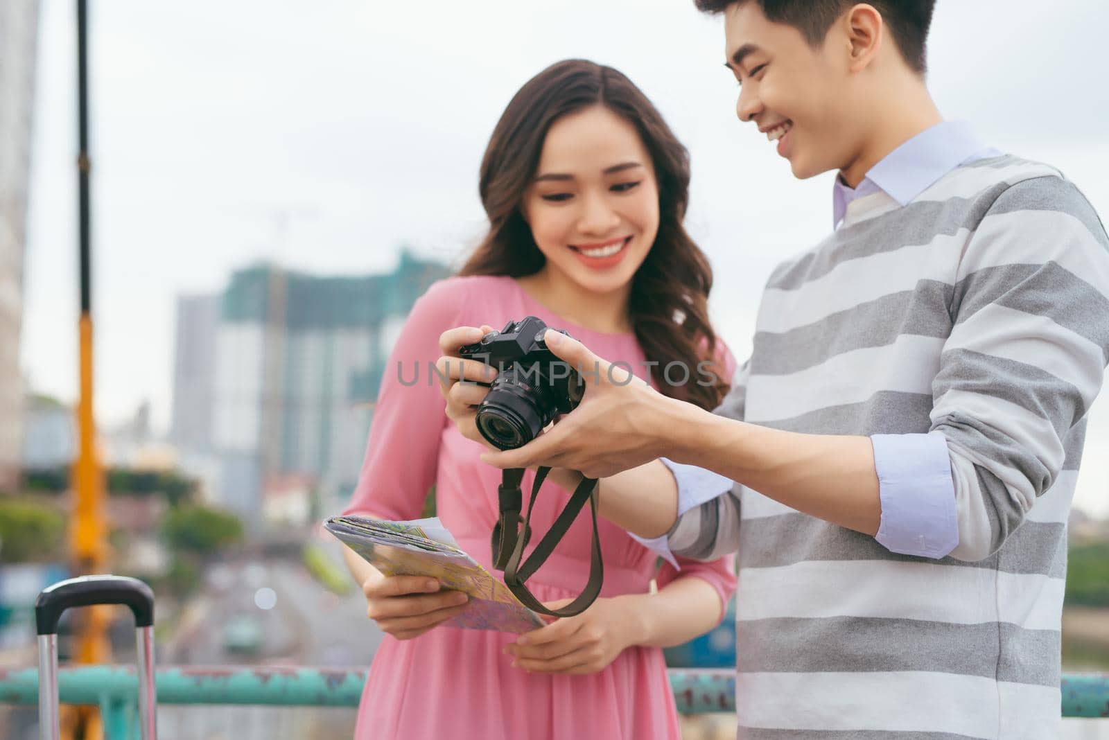 Young lovers walking around city on vacation, enjoying traveling together, outdoors. Focus on camera.