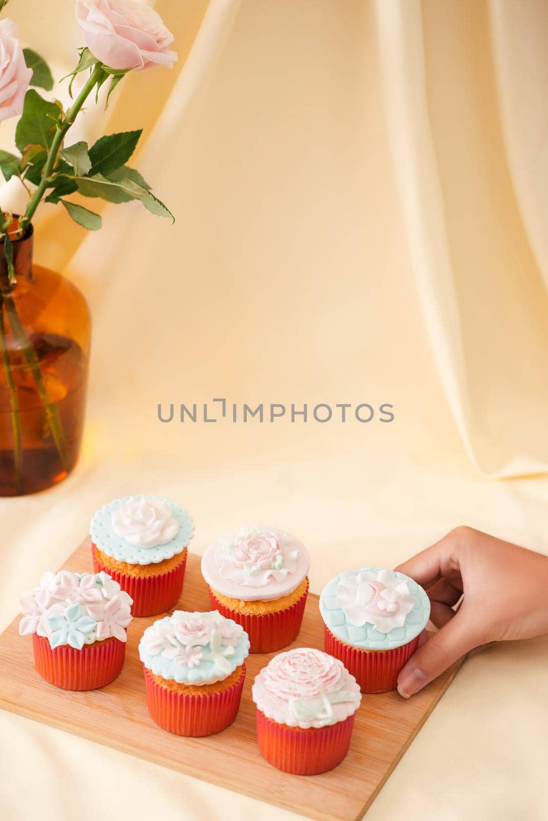 Female hands cut the delicious cupcakes on table  by makidotvn