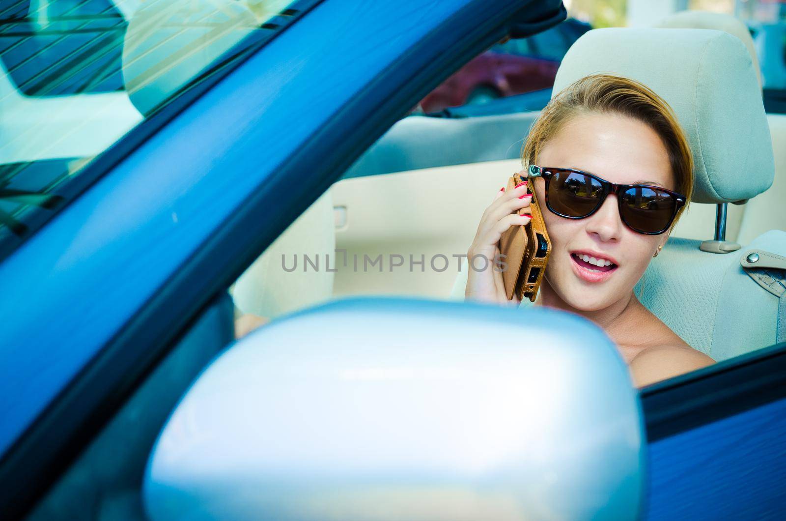 Beautiful blond woman driving her convertible car