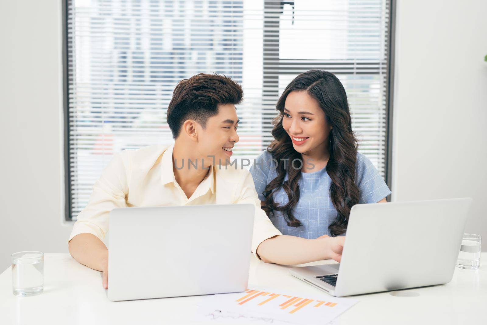 Young business team working together at a laptop, man and woman