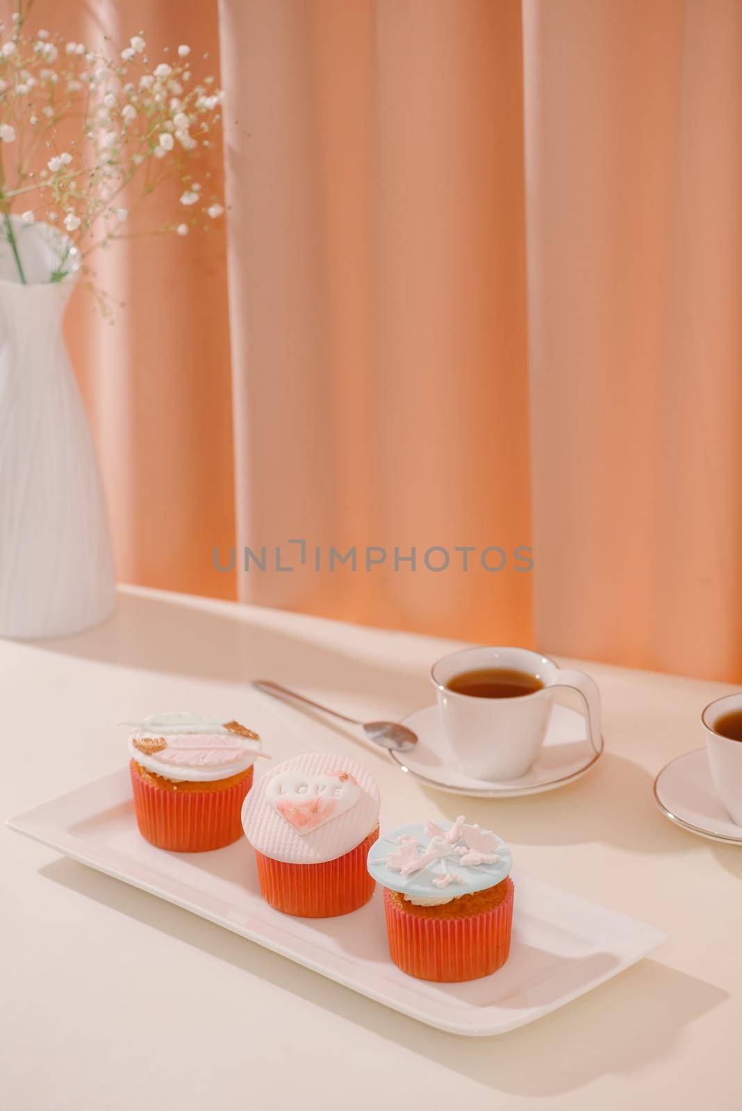 Cupcakes decorated with fondant. Valentine sweet love cupcake on table on light background by makidotvn
