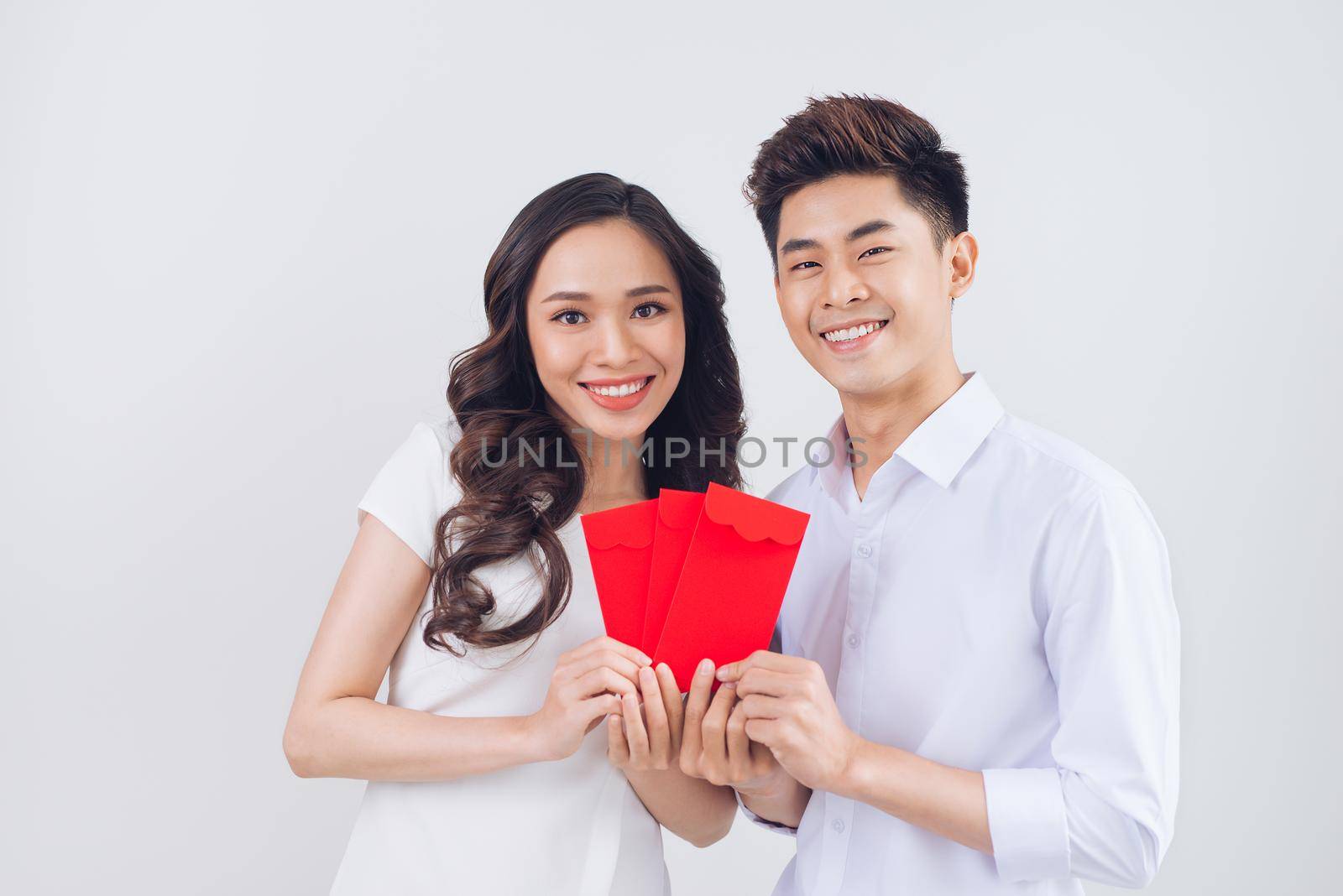 Vietnamese couple exchanging red lucky money envelopes. Tet holiday.