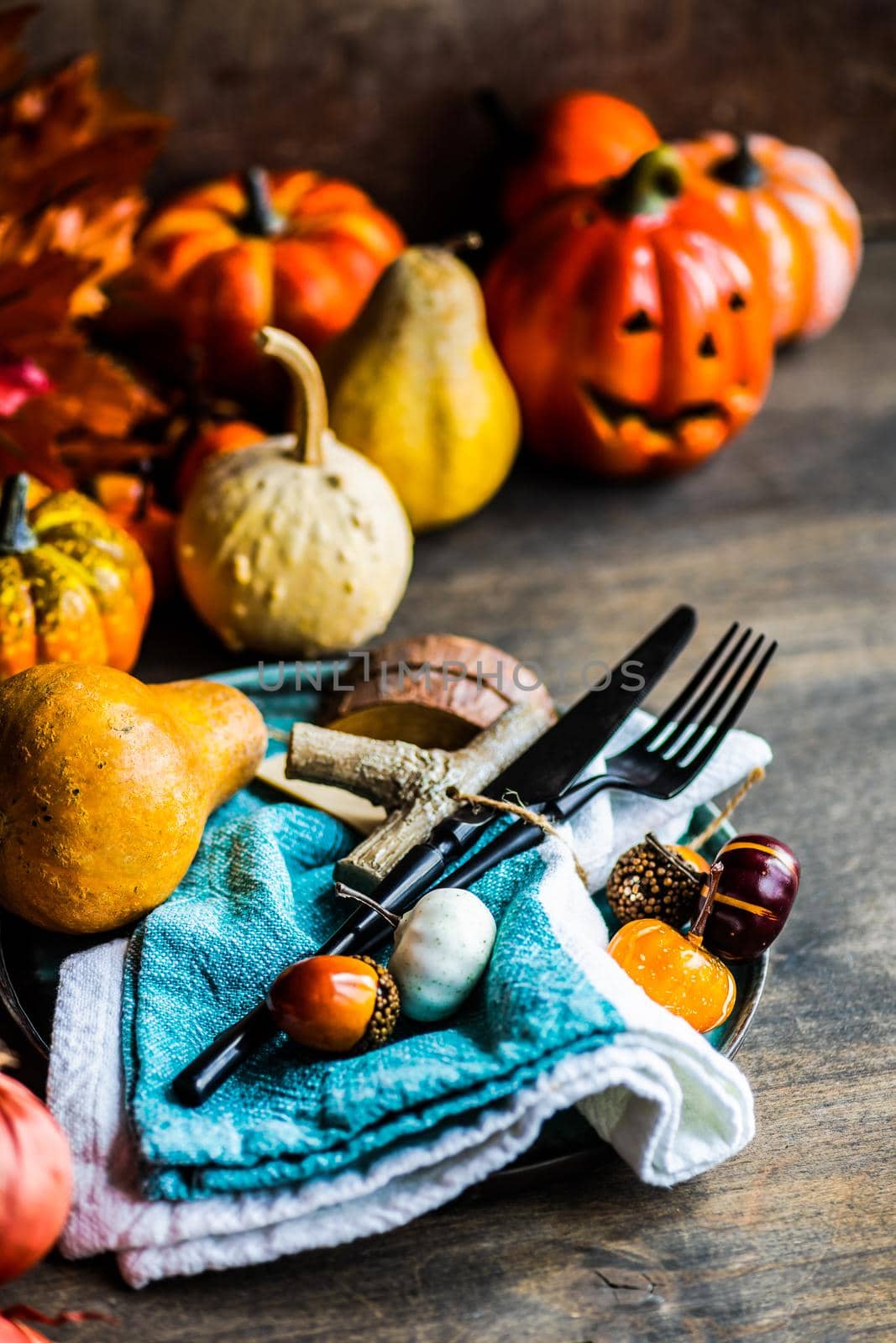 Autumnal table setting with leaves and  pumpkin on wooden table