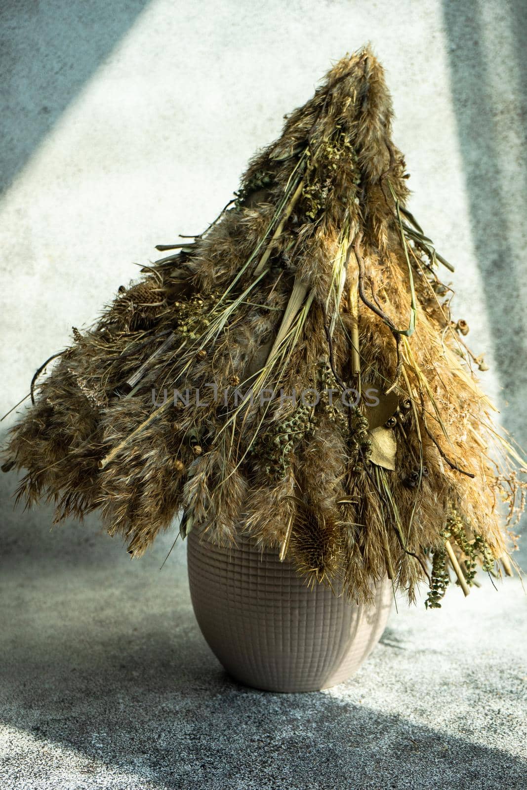 Christmas interior decoration with xmas tree made with dry grass, branches and leaves