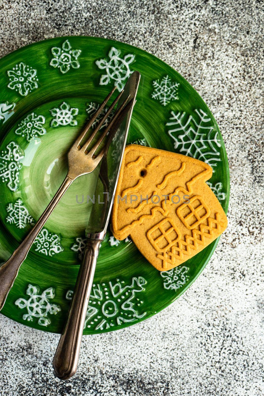 Festive table setting decorated with gingerbread cookie for Christmas dinner