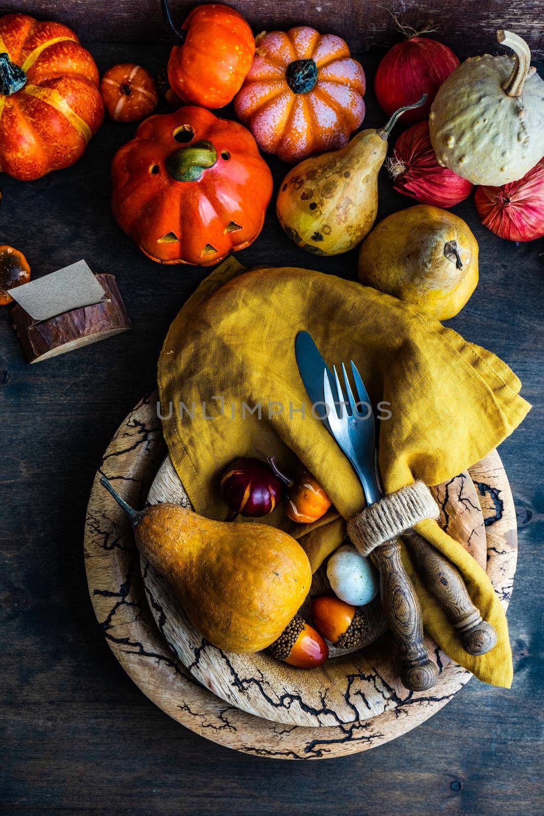 Autumnal table setting with leaves and  pumpkin on wooden table