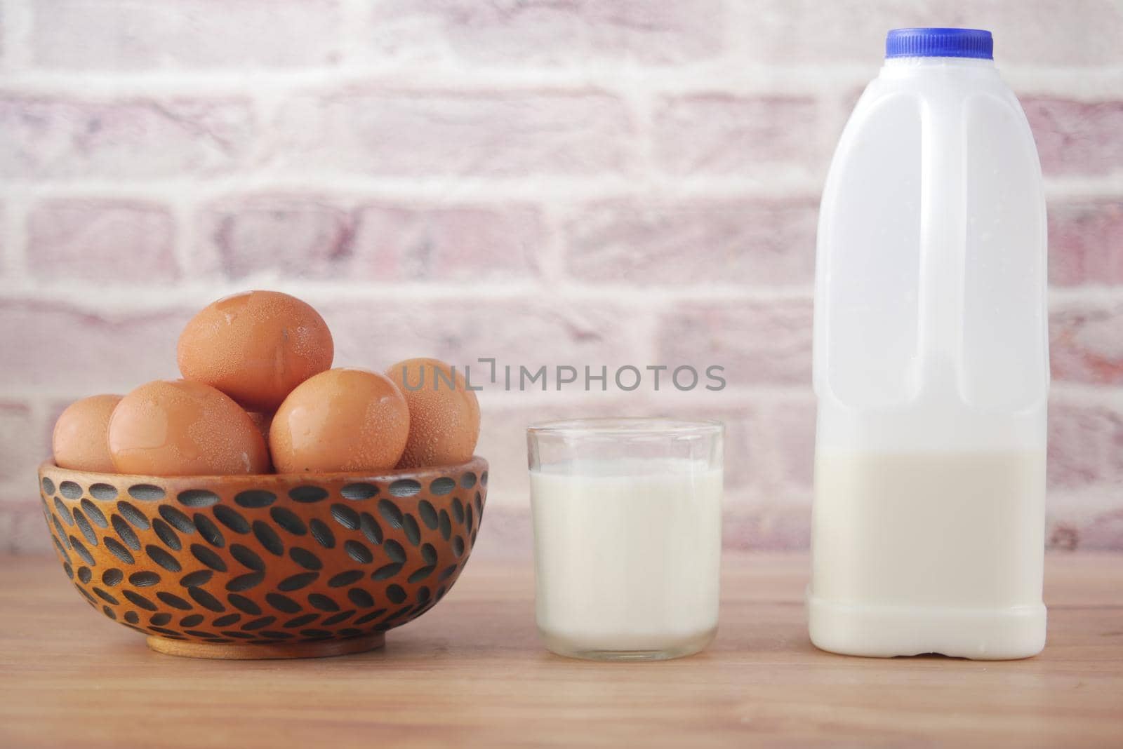 eggs in a bow and a glass of milk on table ,