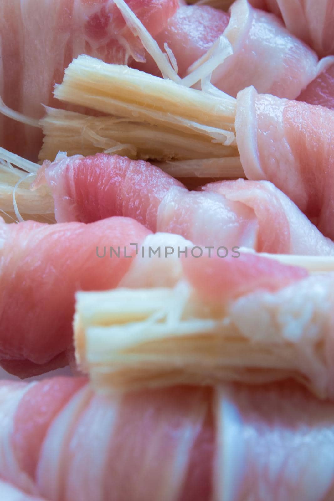 Needle Mushroom in the roll of thin sliced pork prepare to cook by Satakorn