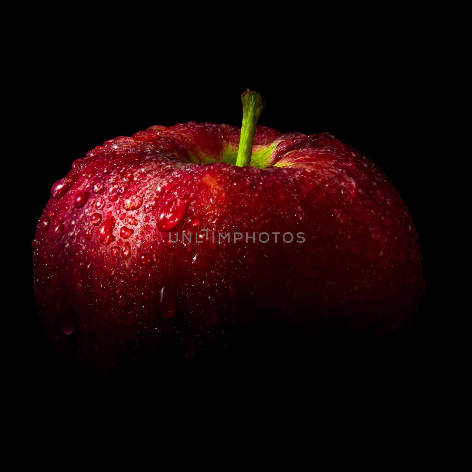 Close-up of Water droplet on glossy surface of freshness red apple on black background