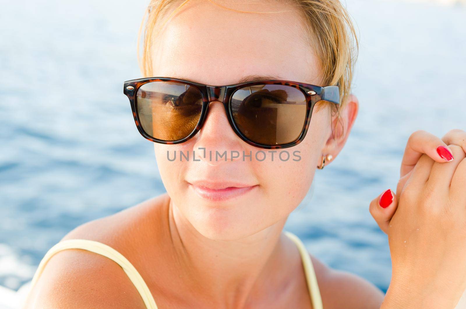 Beautiful red woman enjoying yacht cruise on a hot summer day
