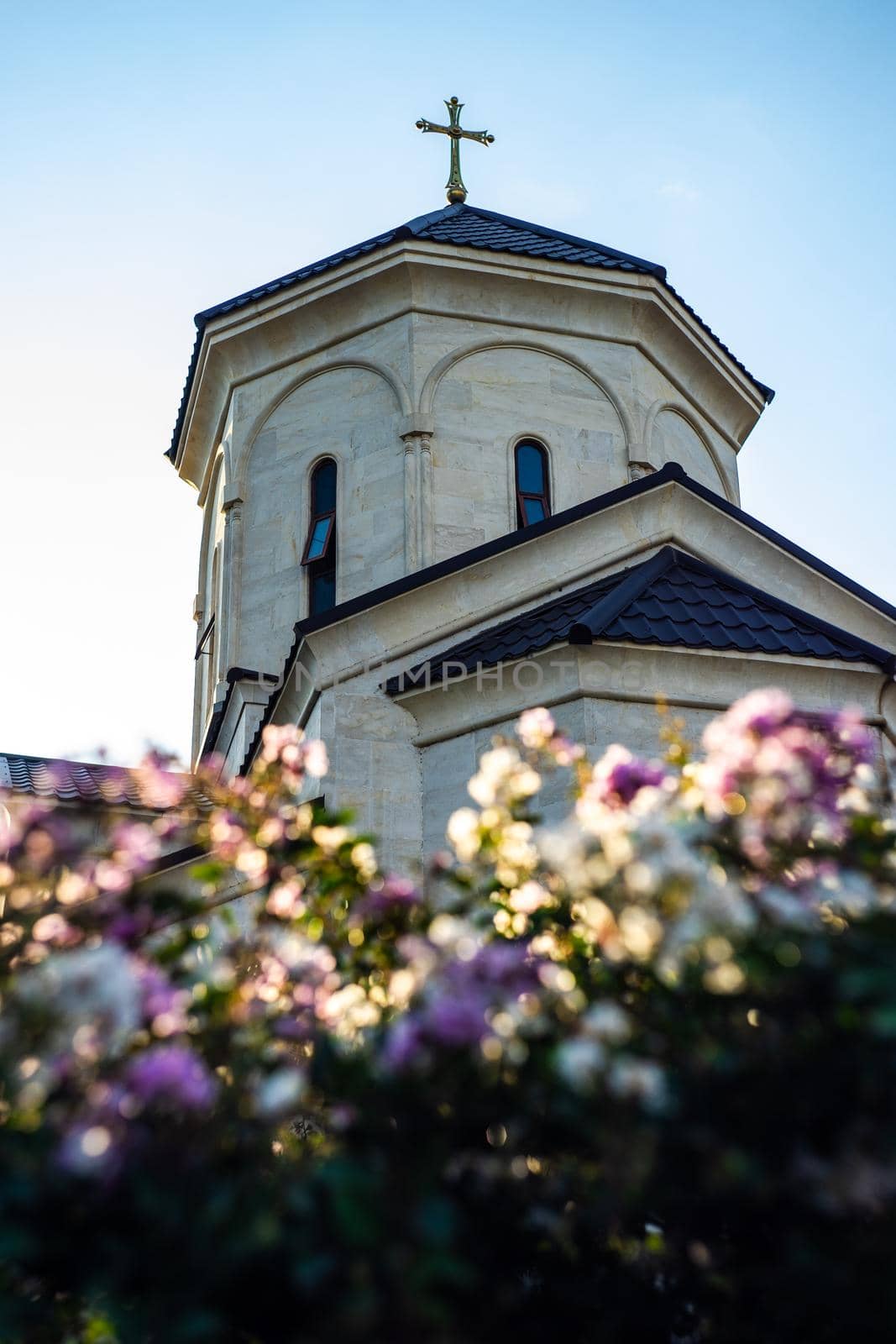 Traditional georgian church architecture on the blooming bush background