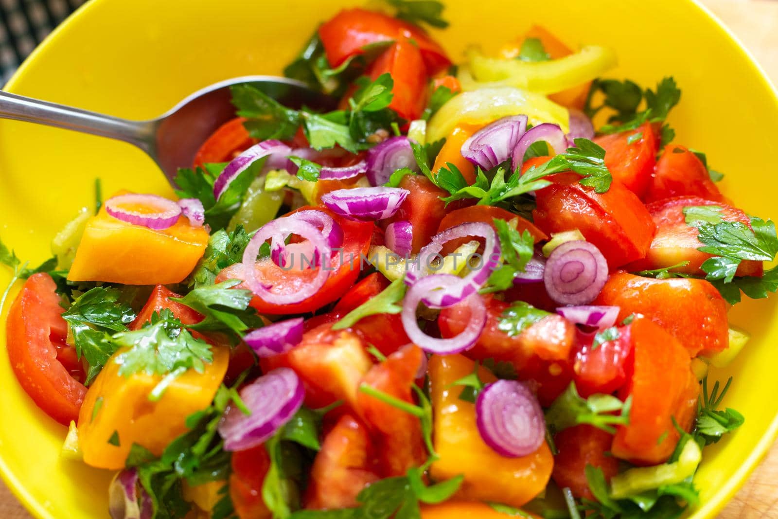 Colorful salad of fresh vegetables in a cup, close-up. Cooking tomato, pepper and onion snacks.