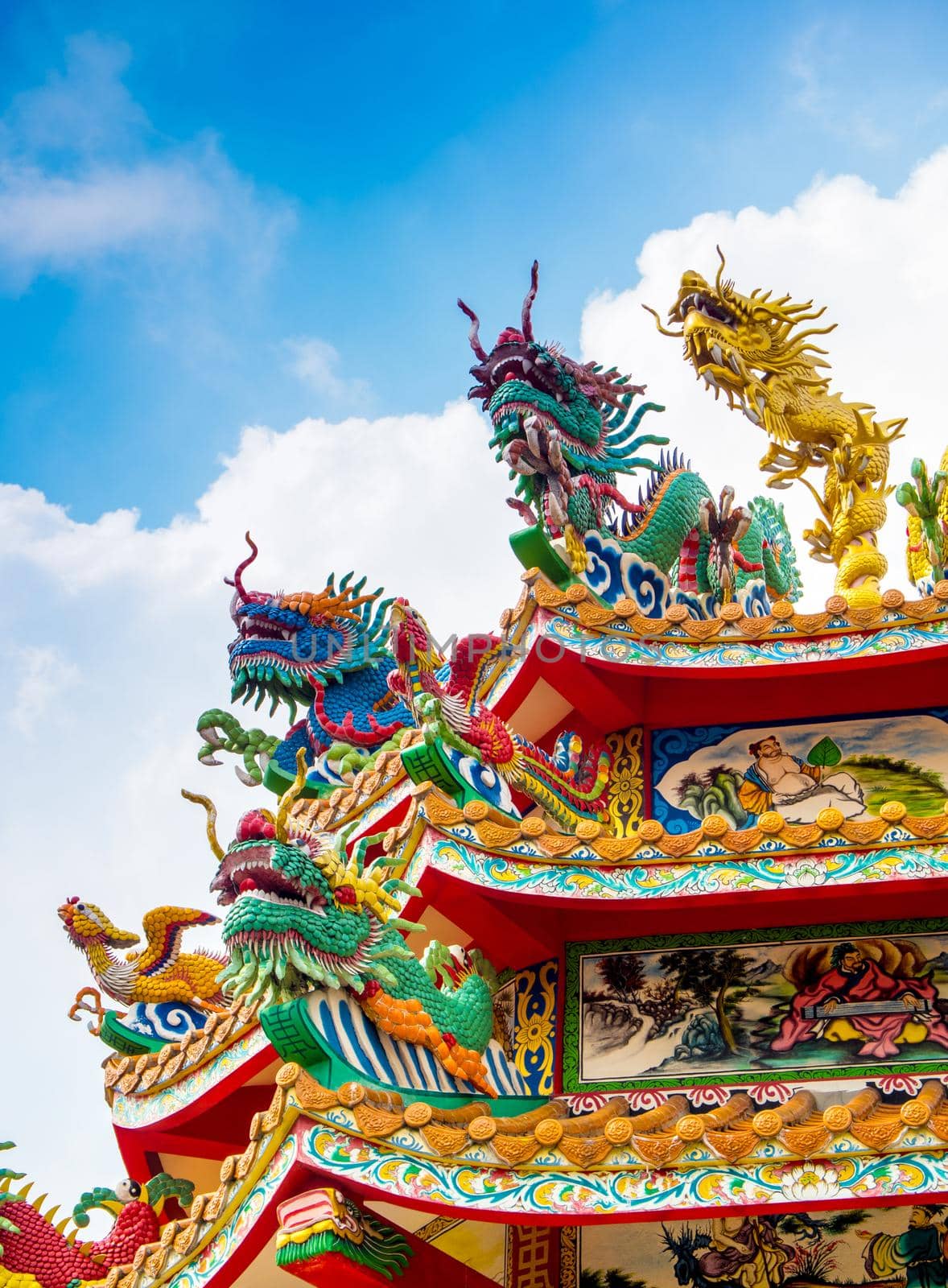 Colorful chinese dragon and swan sculpture on the rooftops of chinese temple by Satakorn