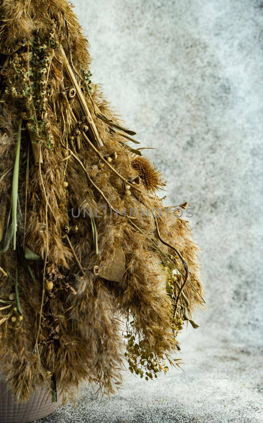 Christmas interior decoration with xmas tree made with dry grass, branches and leaves