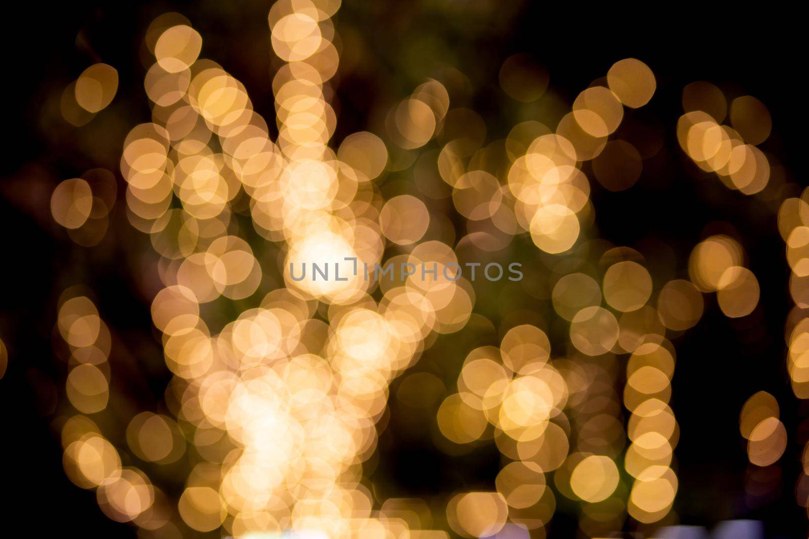 Gold or yellow bokeh texture background with glowing and illuminated, holiday and festive for celebration, New Year or Merry Christmas, no people, blur and defocused with graphic or effect. by nnudoo