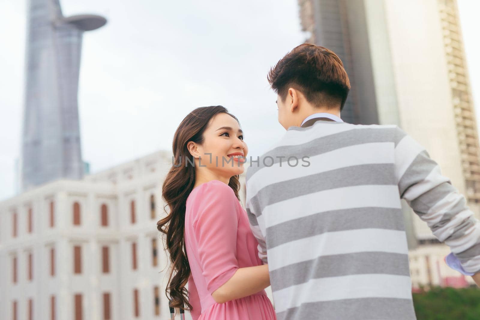 Young lovers walking around city on vacation, enjoying traveling together, outdoors.