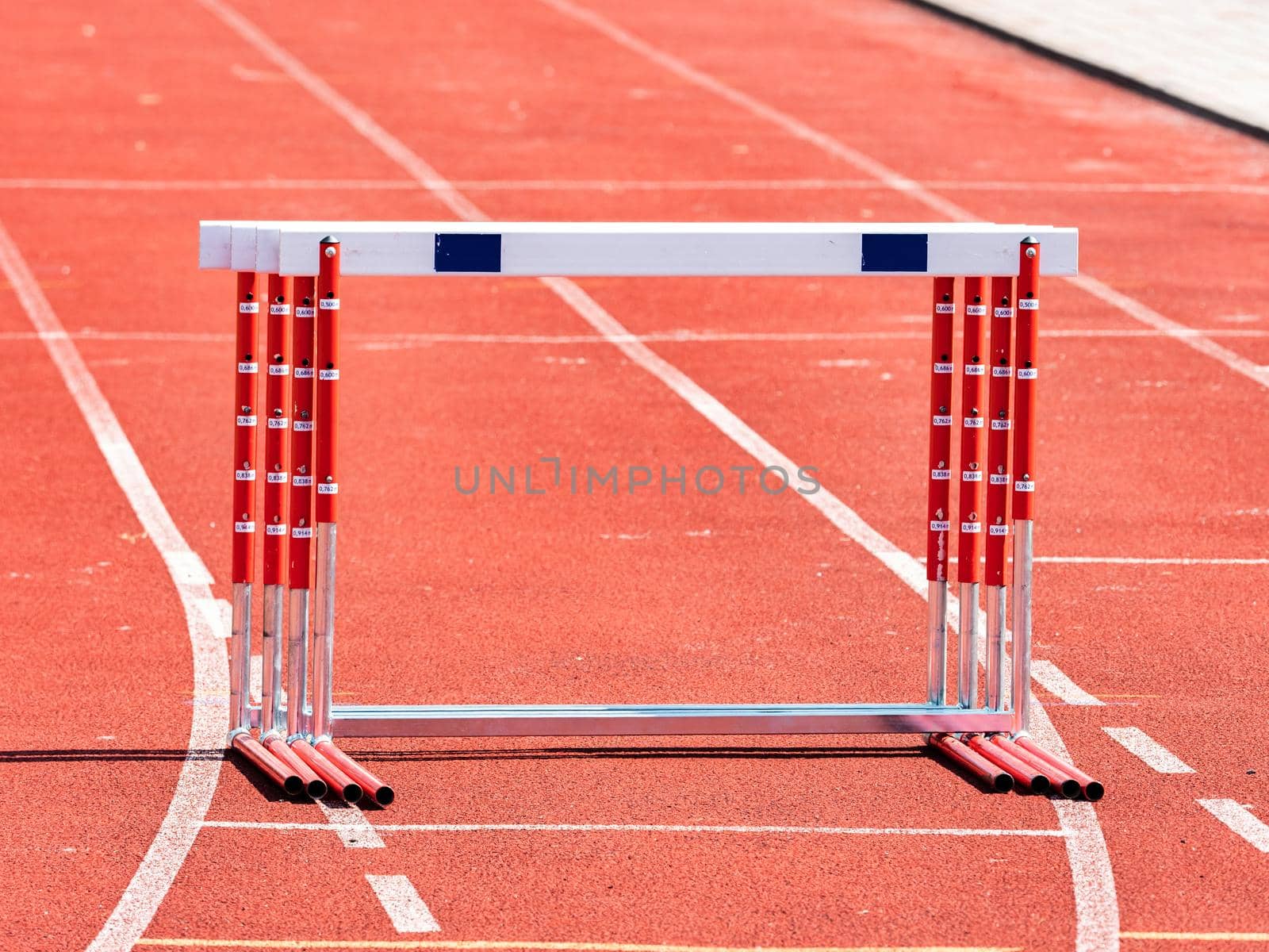 Hurdles and red running tracks in a stadion. Beginning of athletic training