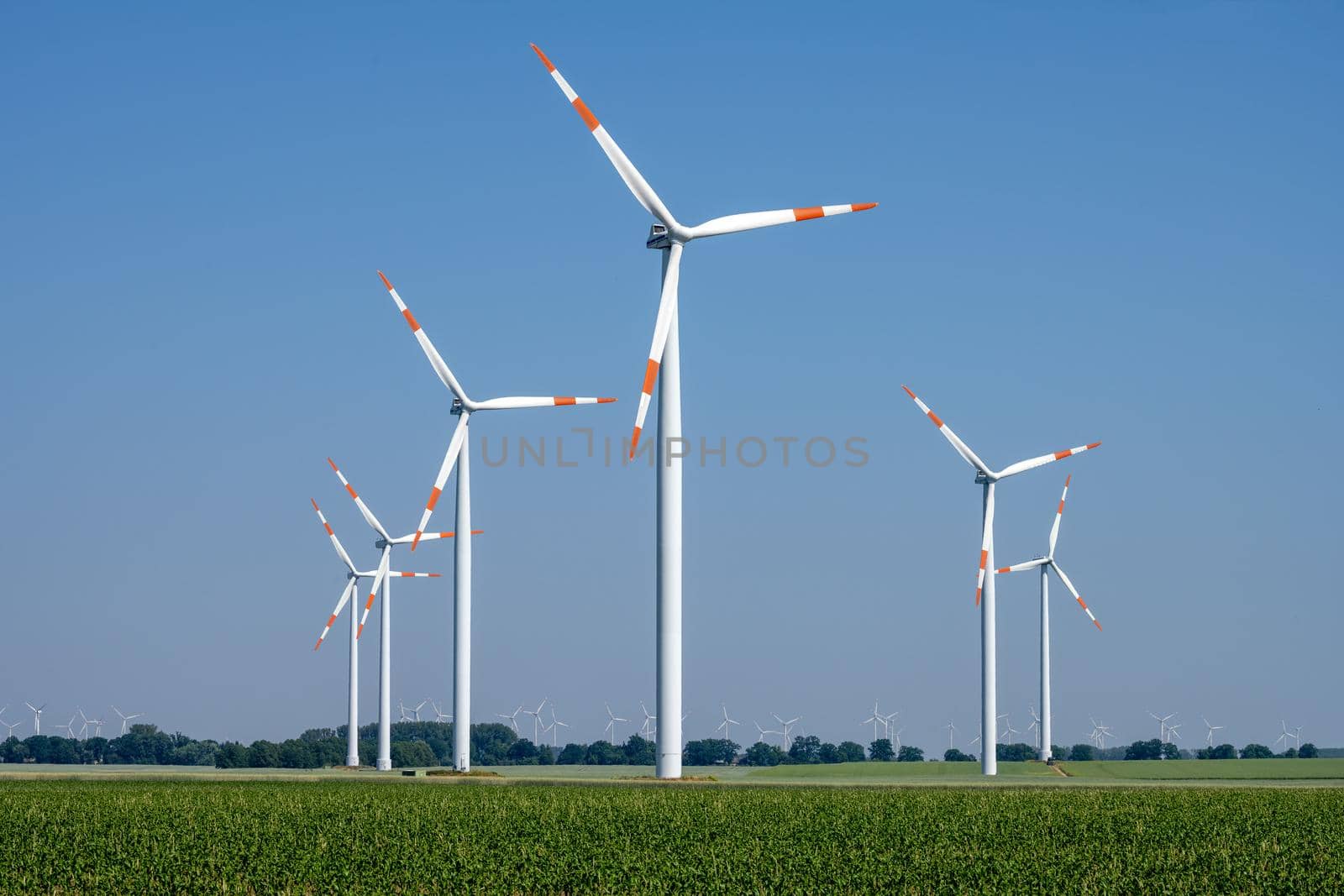 Modern wind turbines in front of a clear blue sky seen in Germany
