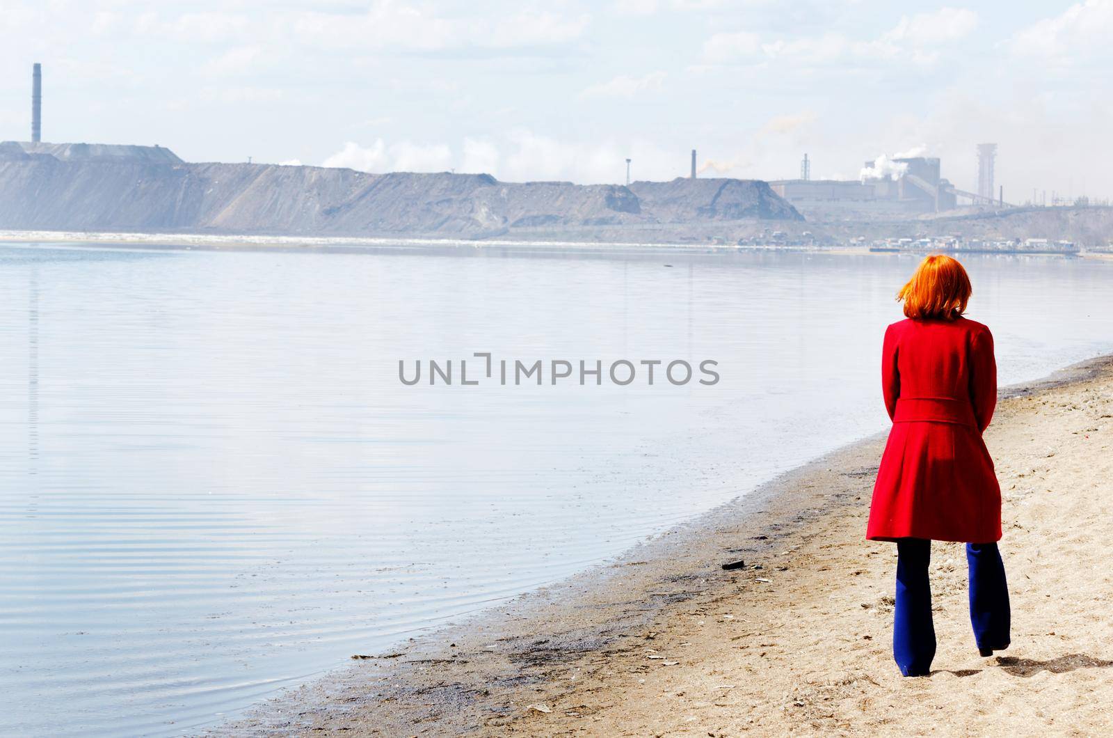 Young woman walks alone on a beach