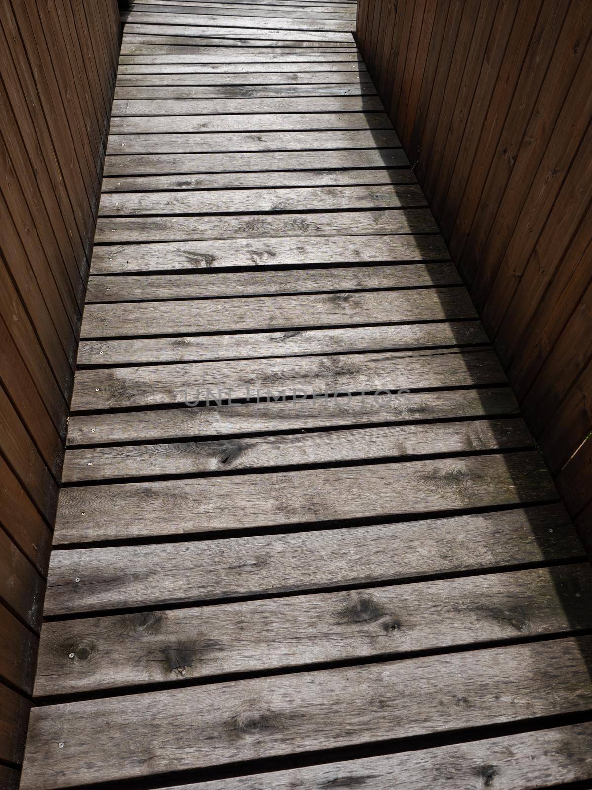 Wet wooden planks of path for wheelchairs, another castle entrance. Barrier free path for visitors.