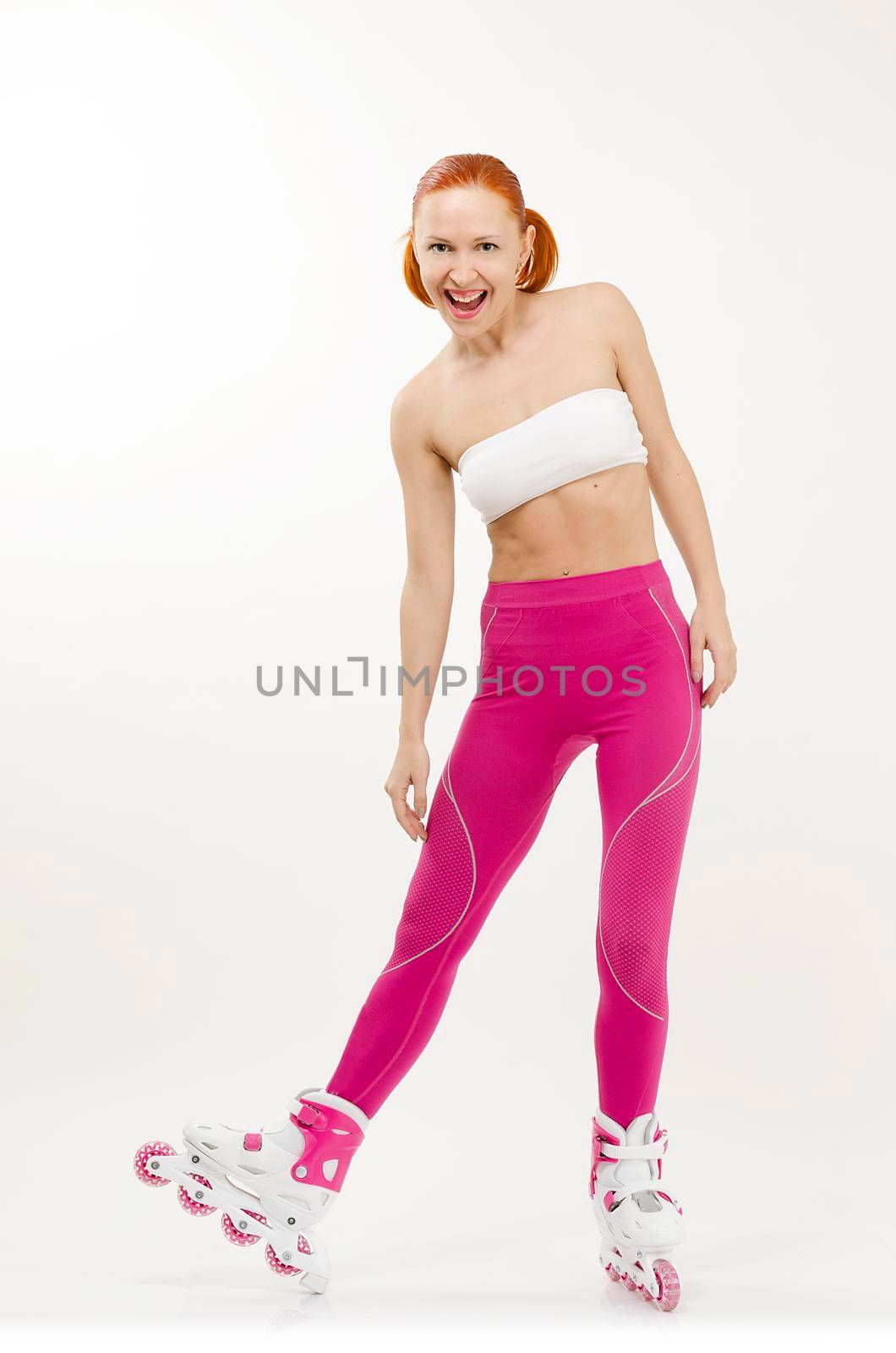 Beautiful young red woman on a pink roller skates