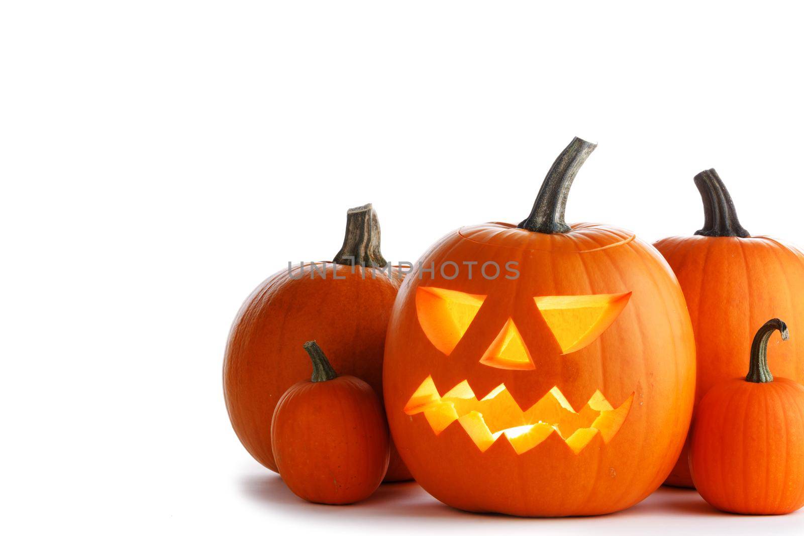 Halloween pumpkin with cut face and candle inside isolated on white background