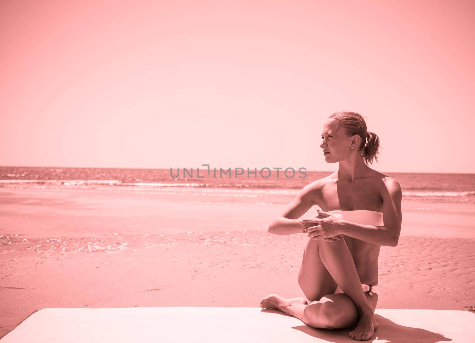 Woman doing yoga asana at the beach