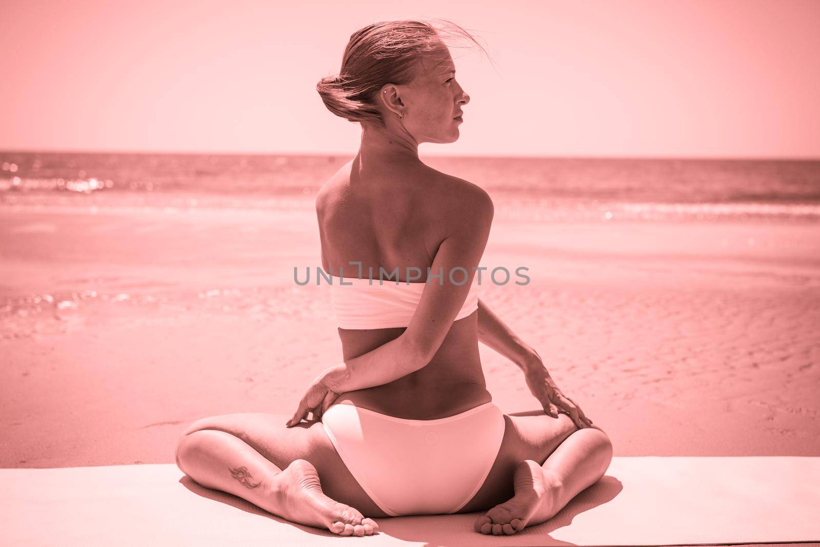 Woman doing yoga asana at the beach