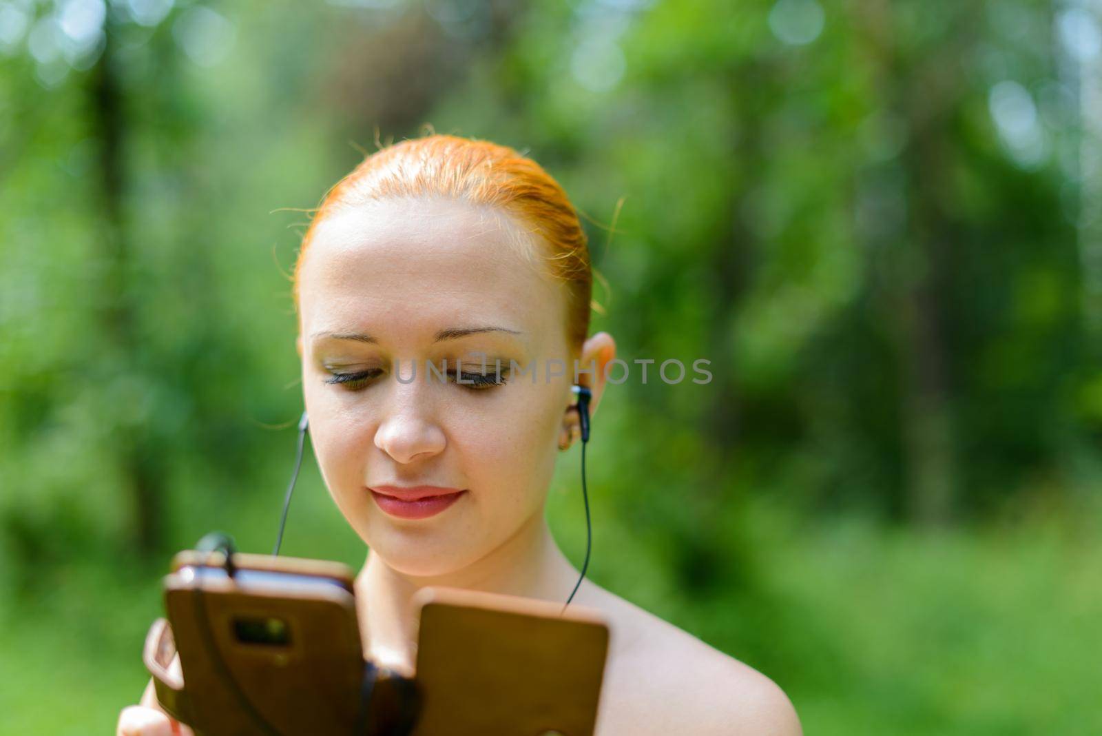 Attractive young woman listening to music with mp3 player and earphone on bokeh background