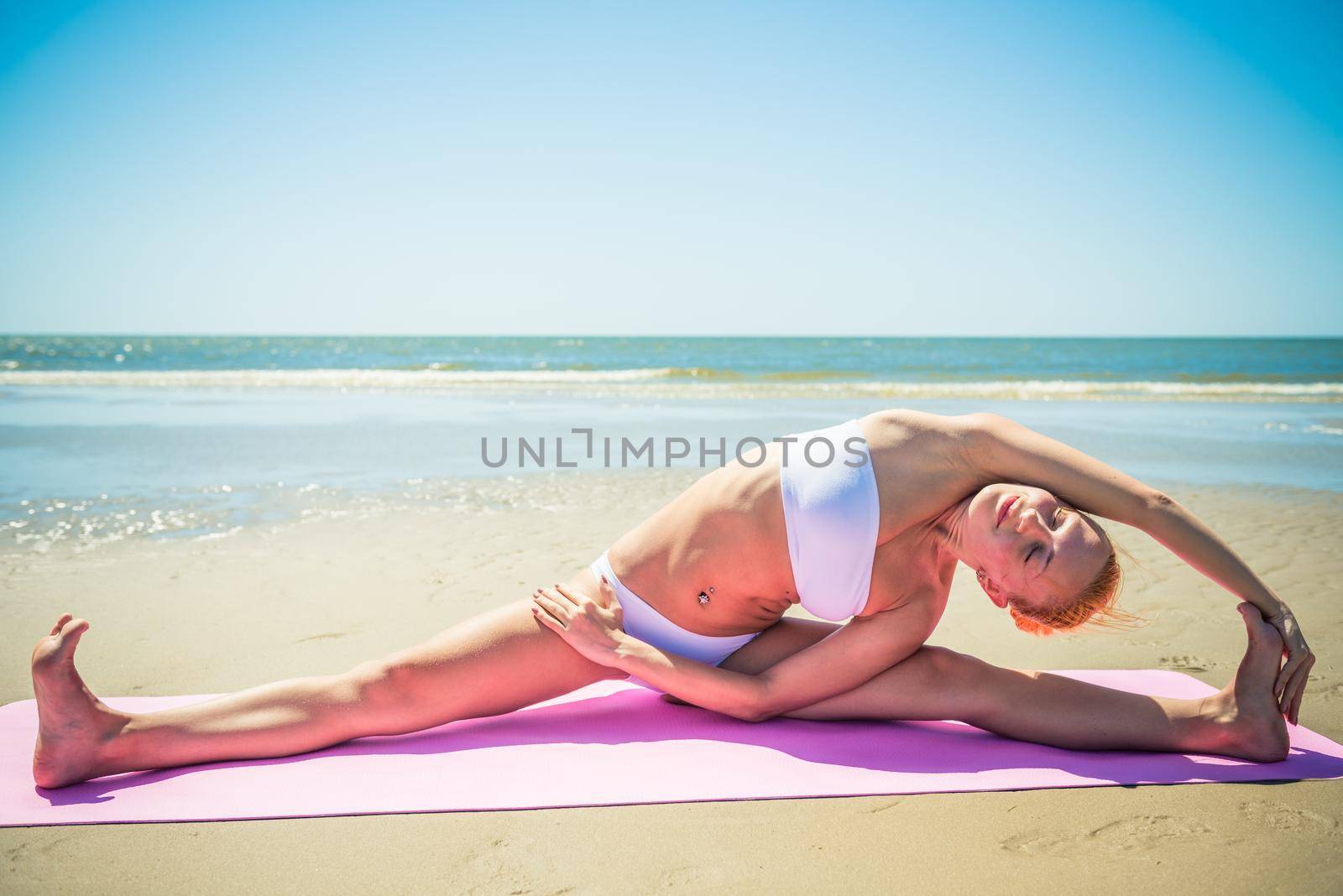 Woman doing yoga asana at the beach