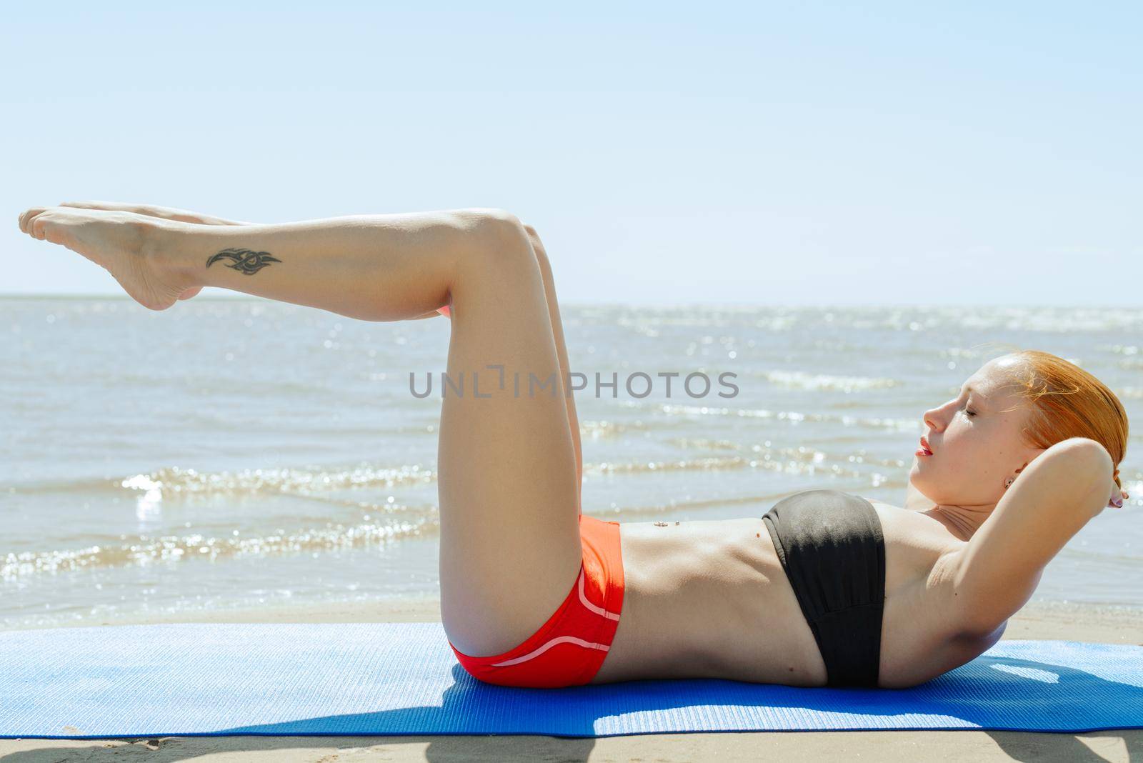 Young woman doing fitness yoga at the beach