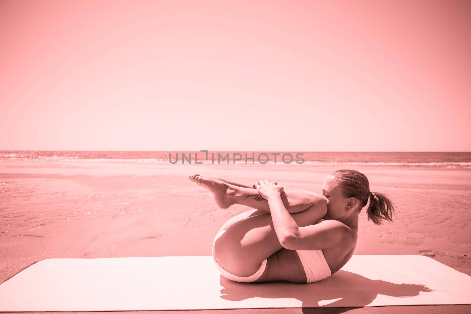 Woman doing yoga asana at the beach