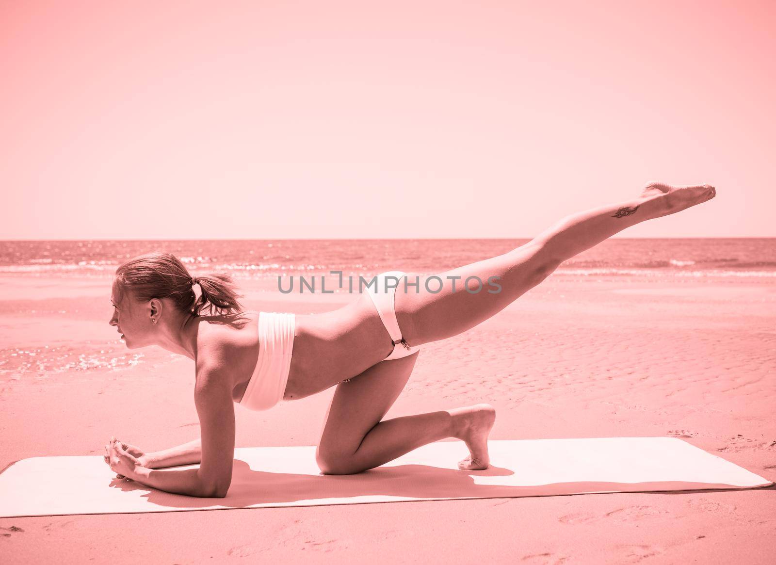 Woman doing yoga asana at the beach
