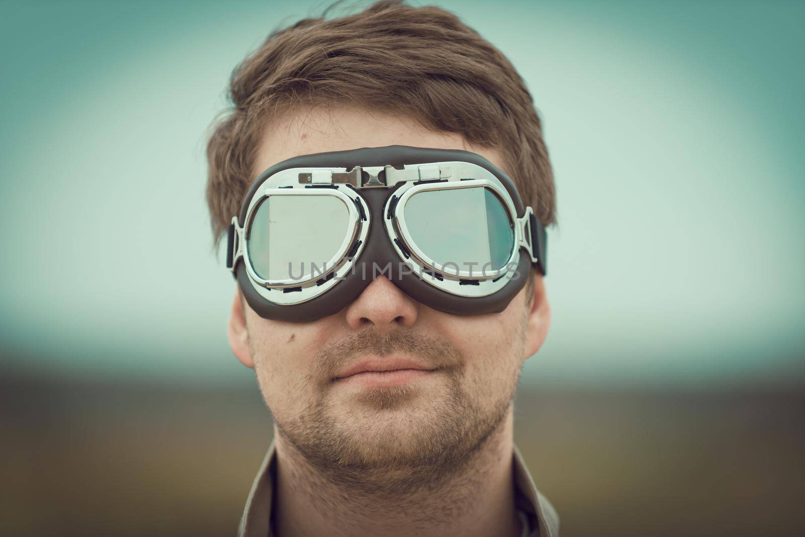 Young man wearing aviator motorcycle glasses at the airfield