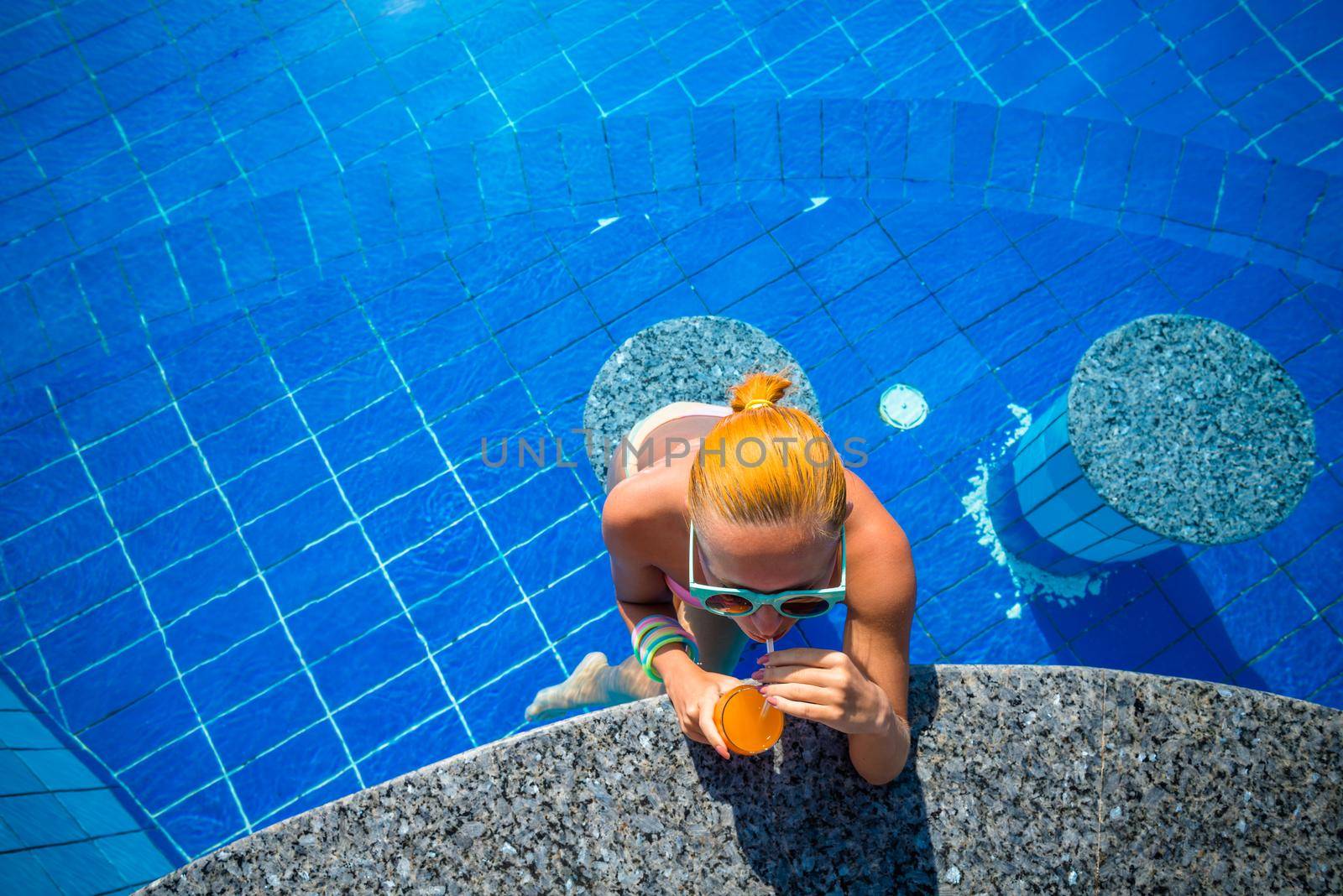 Girl in pool bar at tropical tourist resort vacation destination