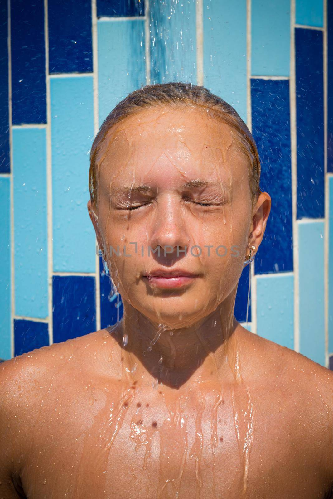 Sensuous slim woman taking shower at the beach