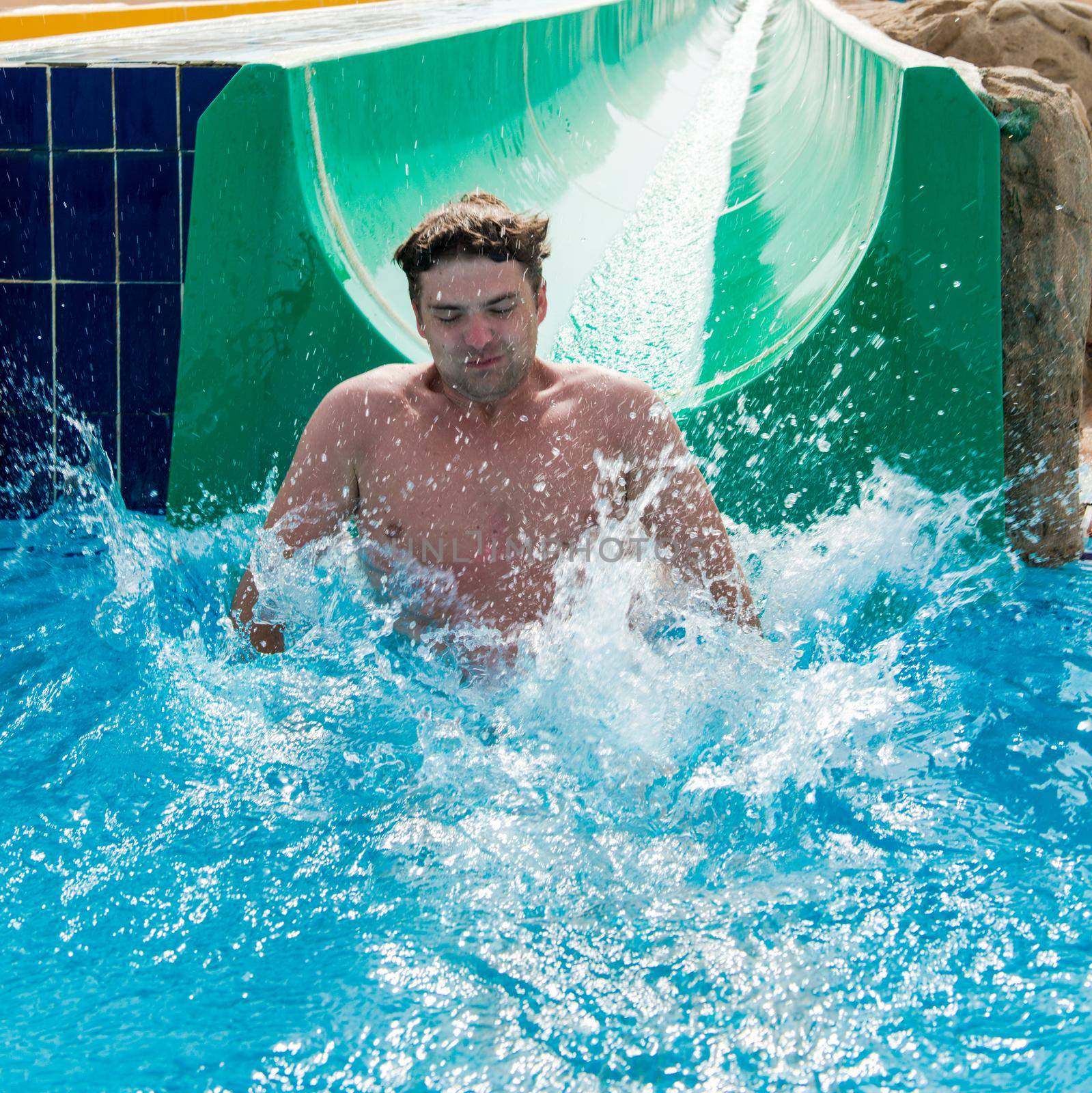 Young man having very good fun at waterslides