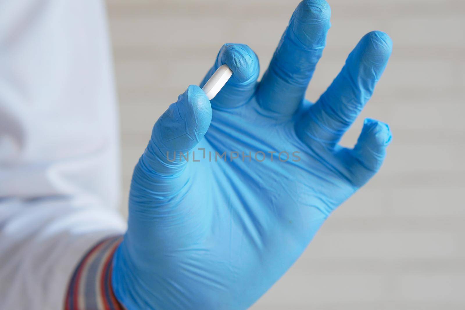 doctor holding medical pill on palm of hand .