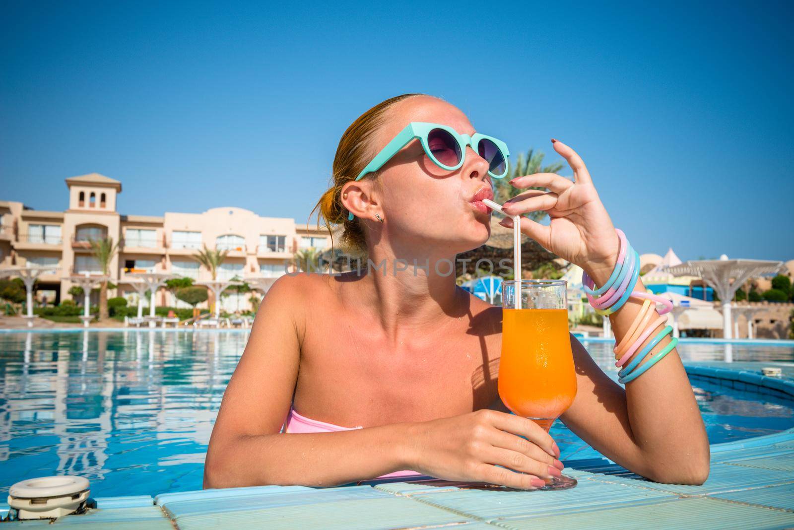 Girl in pool bar at tropical tourist resort vacation destination