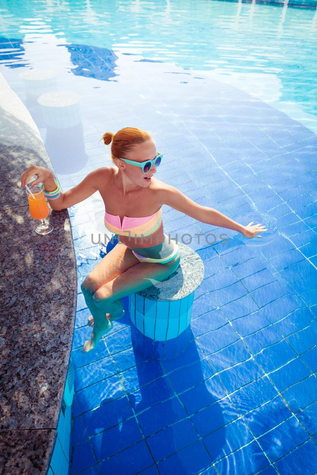 Girl in pool bar at tropical tourist resort vacation destination