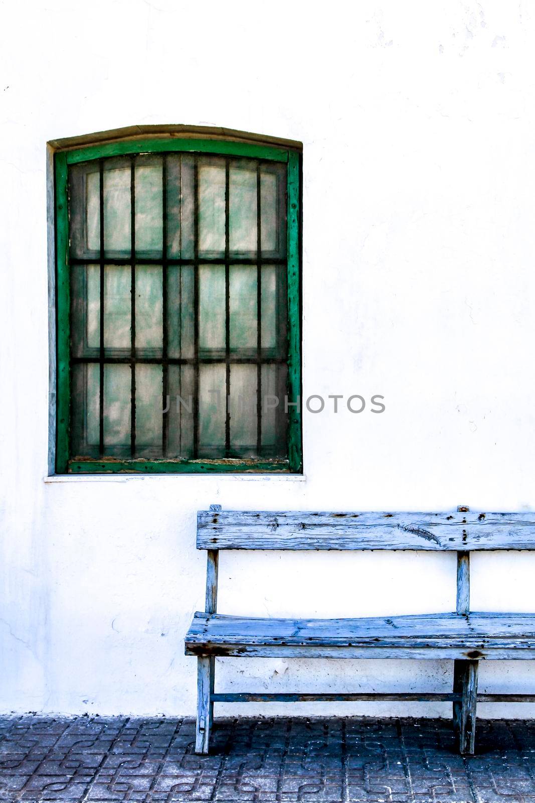 Typical Andalusian whitewashed facade with blue painted window and bench