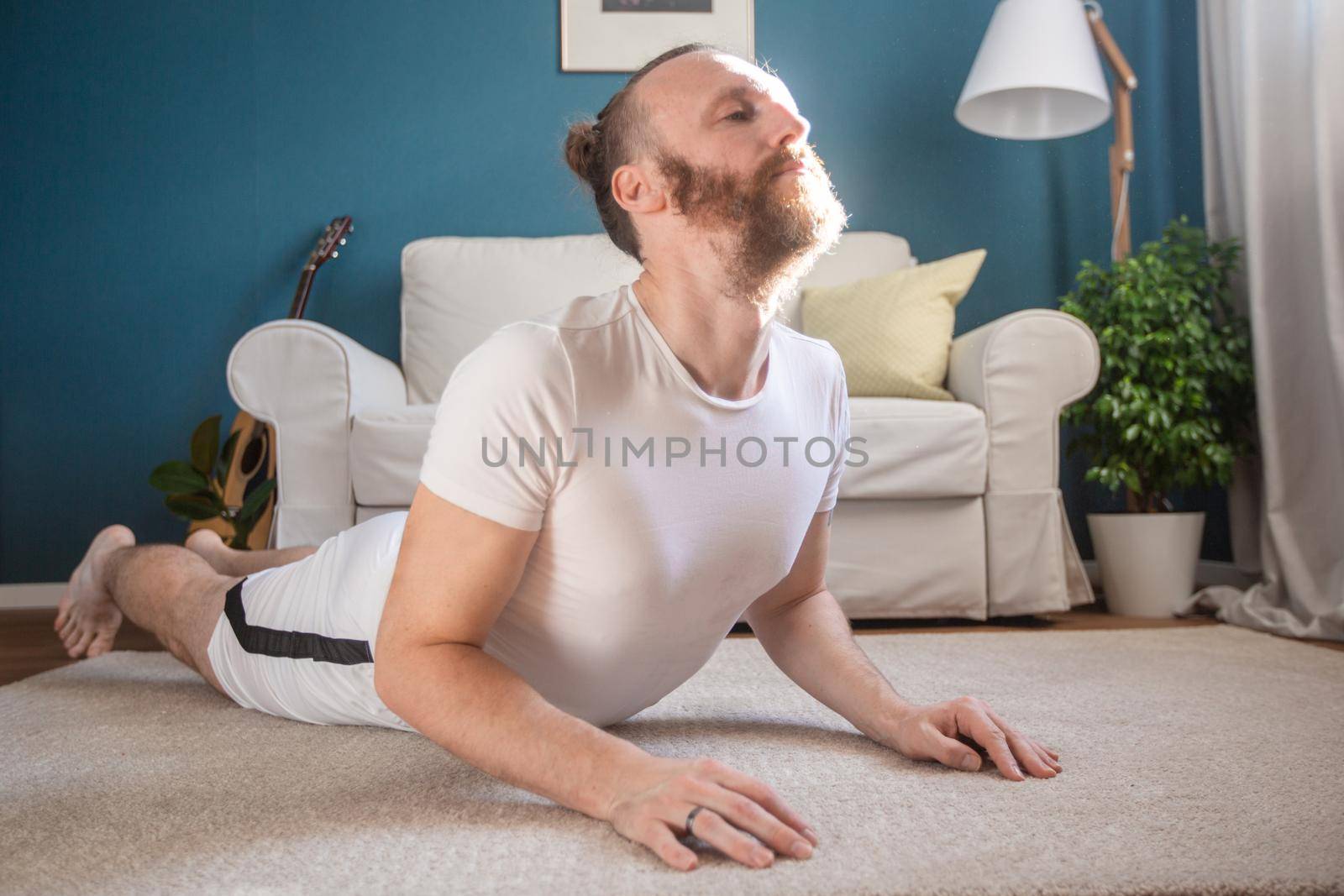 Man practice yoga at home by destillat