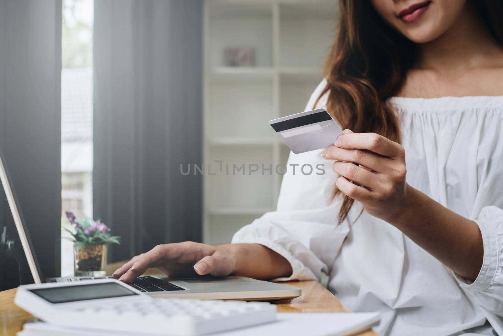 Woman enjoy with online shopping application on laptop computer and typing credit card for fill number to payment