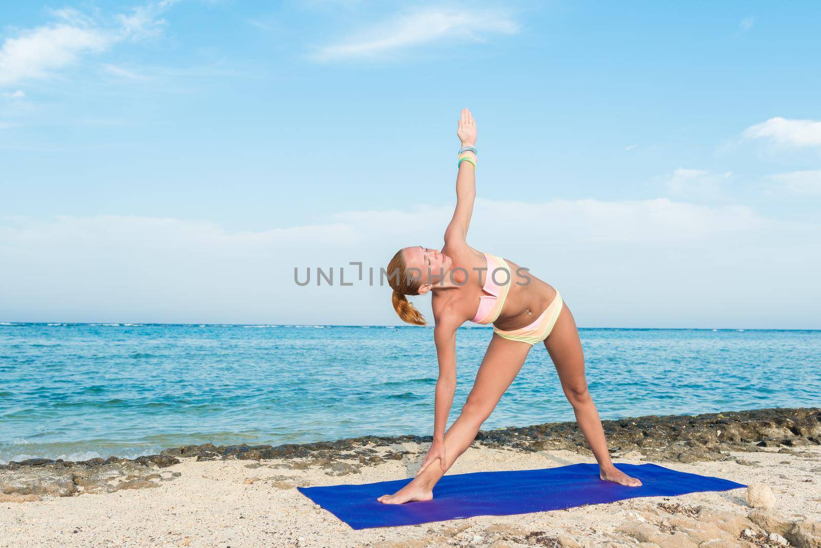 Woman doing yoga asana at the beach