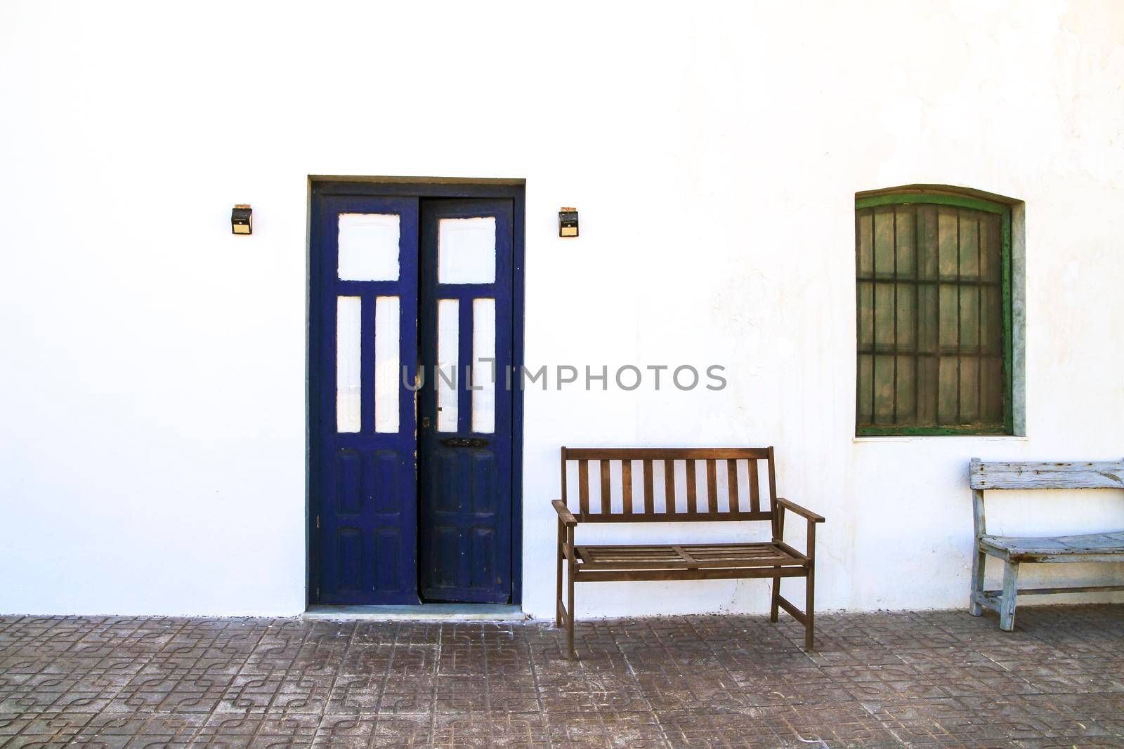 Typical Andalusian whitewashed facade with blue painted window and bench
