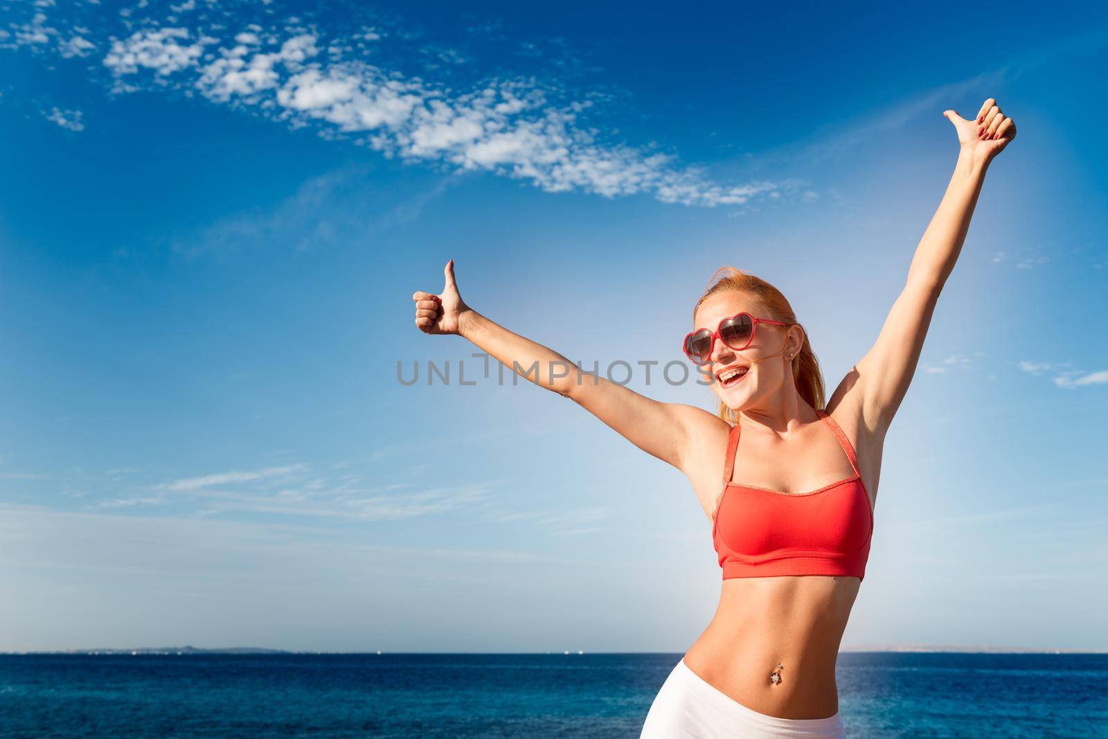 Beautiful young sensuous woman wearing sunglasses and fitness bikini