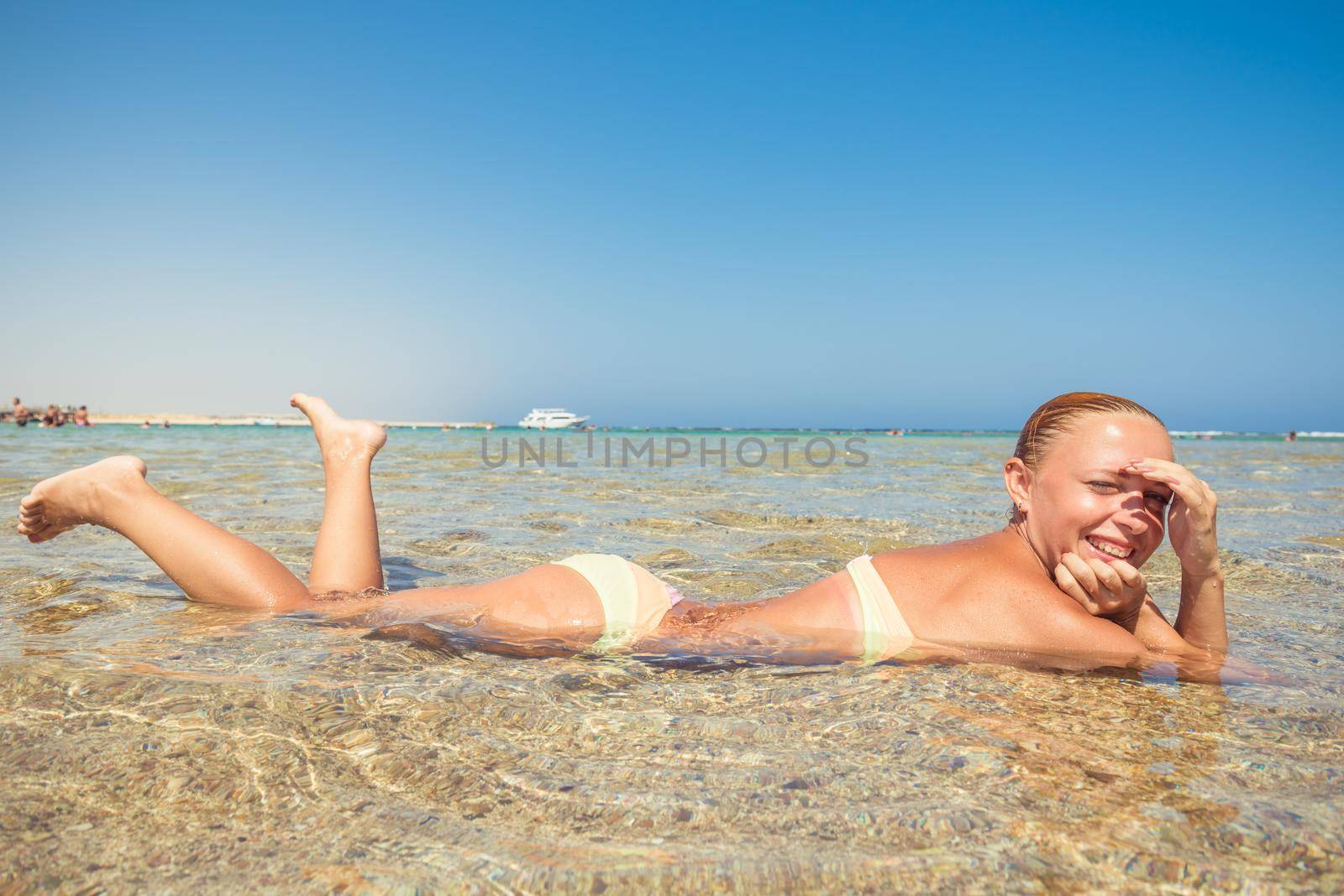 Beautiful woman laying in sea on a hot summer day