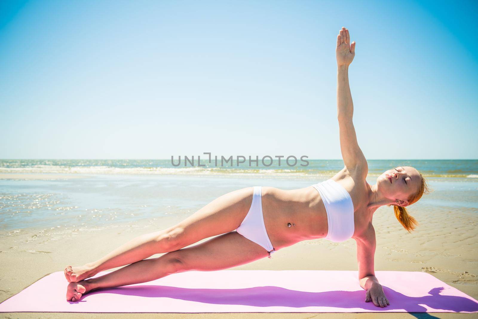 Woman doing yoga asana at the beach