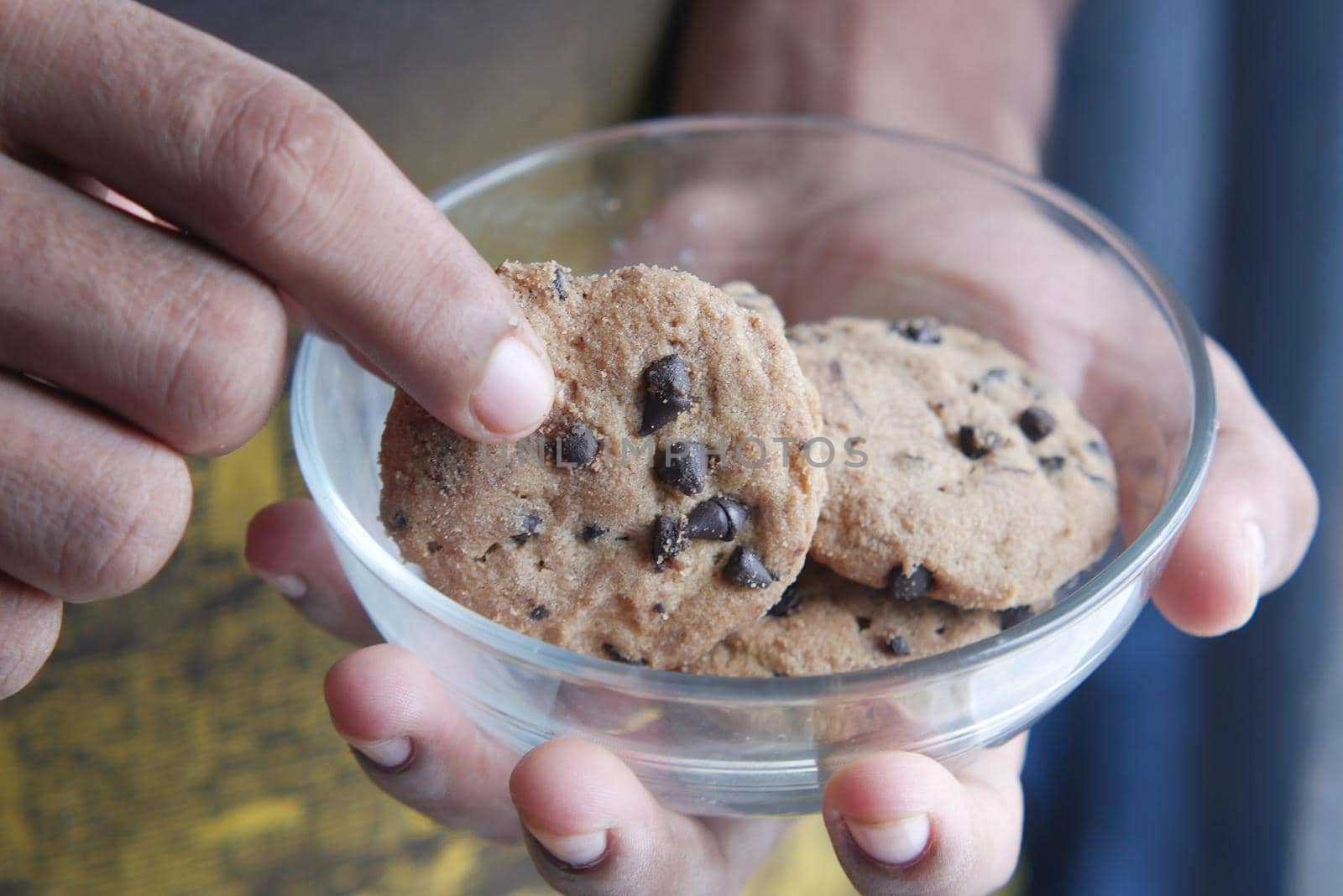 young man hand pick chocolate cookies .