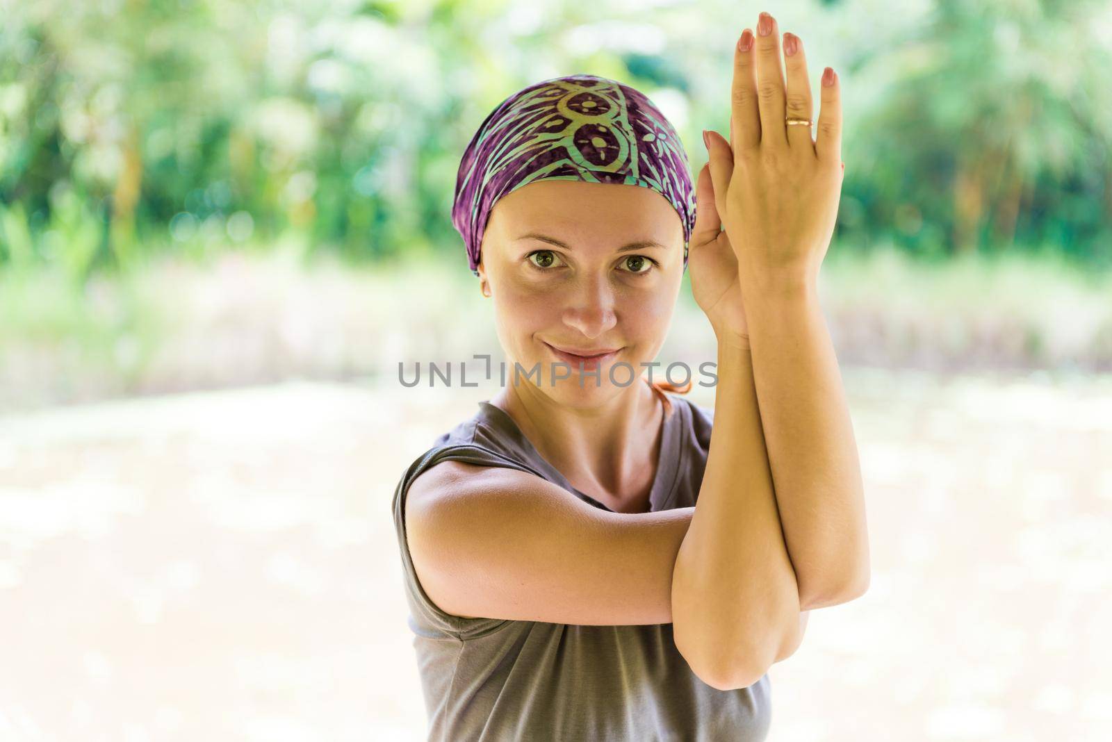 Woman practicing yoga - garudasana pose in park